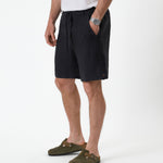 The Holiday Linen Short in black — side view showing the drawstring waist and side pockets