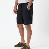 The Holiday Linen Short in black — side view showing the drawstring waist and side pockets