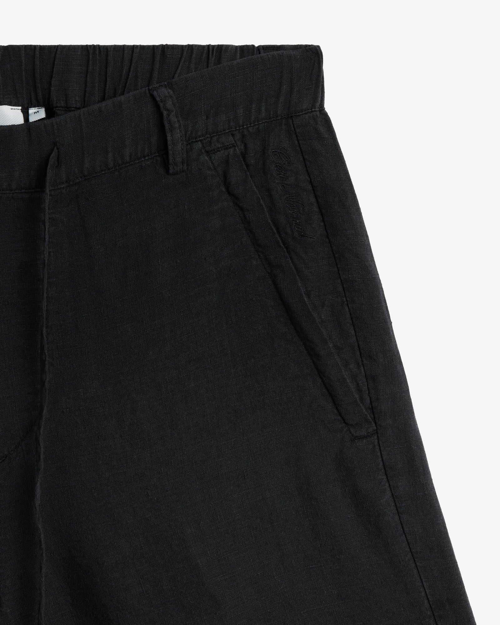 The Holiday Linen Short in black — close-up of the side pocket with tonal embroidery