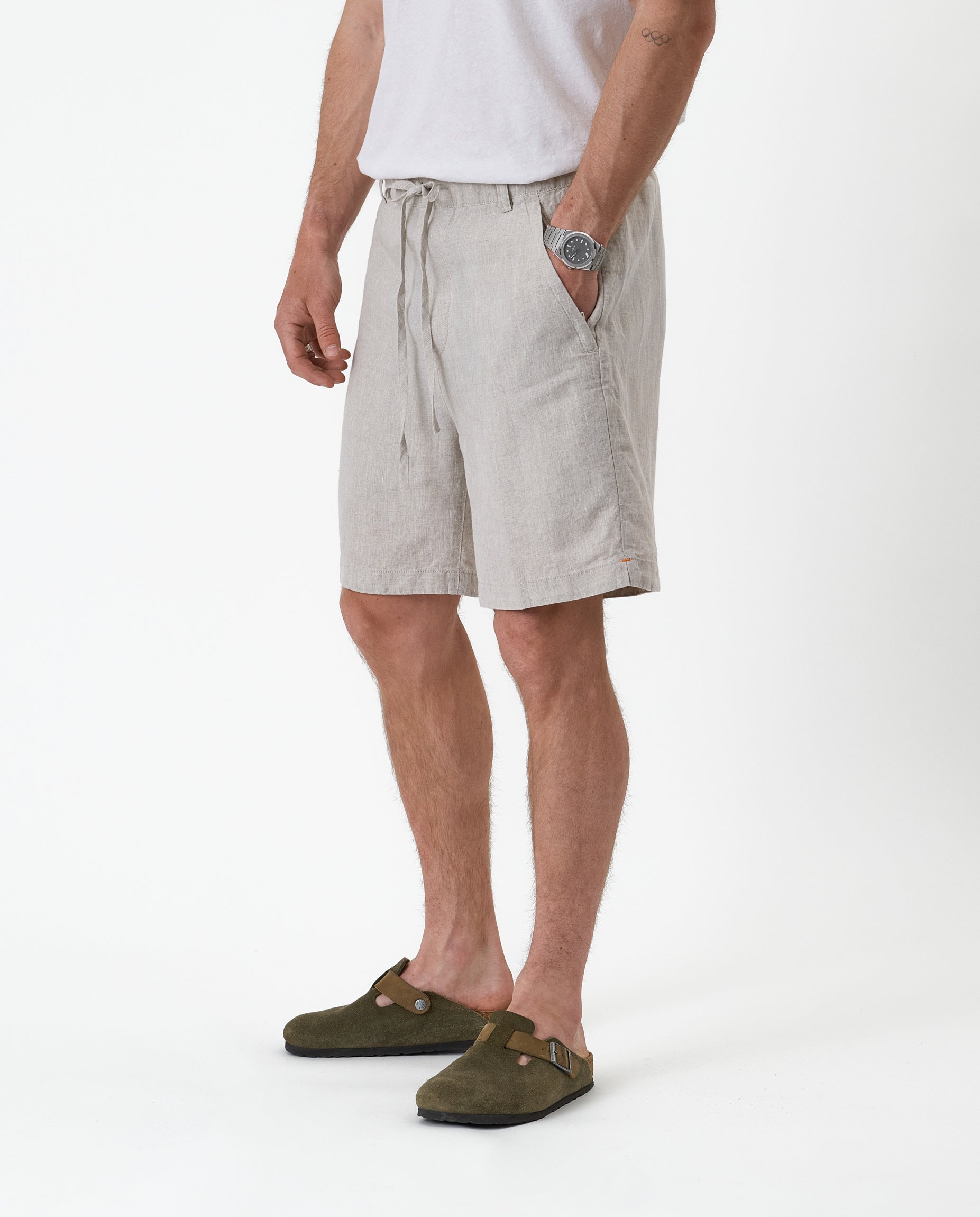 The Holiday Linen Short in natural — side view worn with green suede clogs