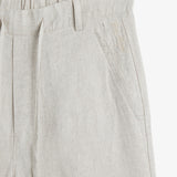 The Holiday Linen Trouser in natural — close-up of the waistband and embroidered logo