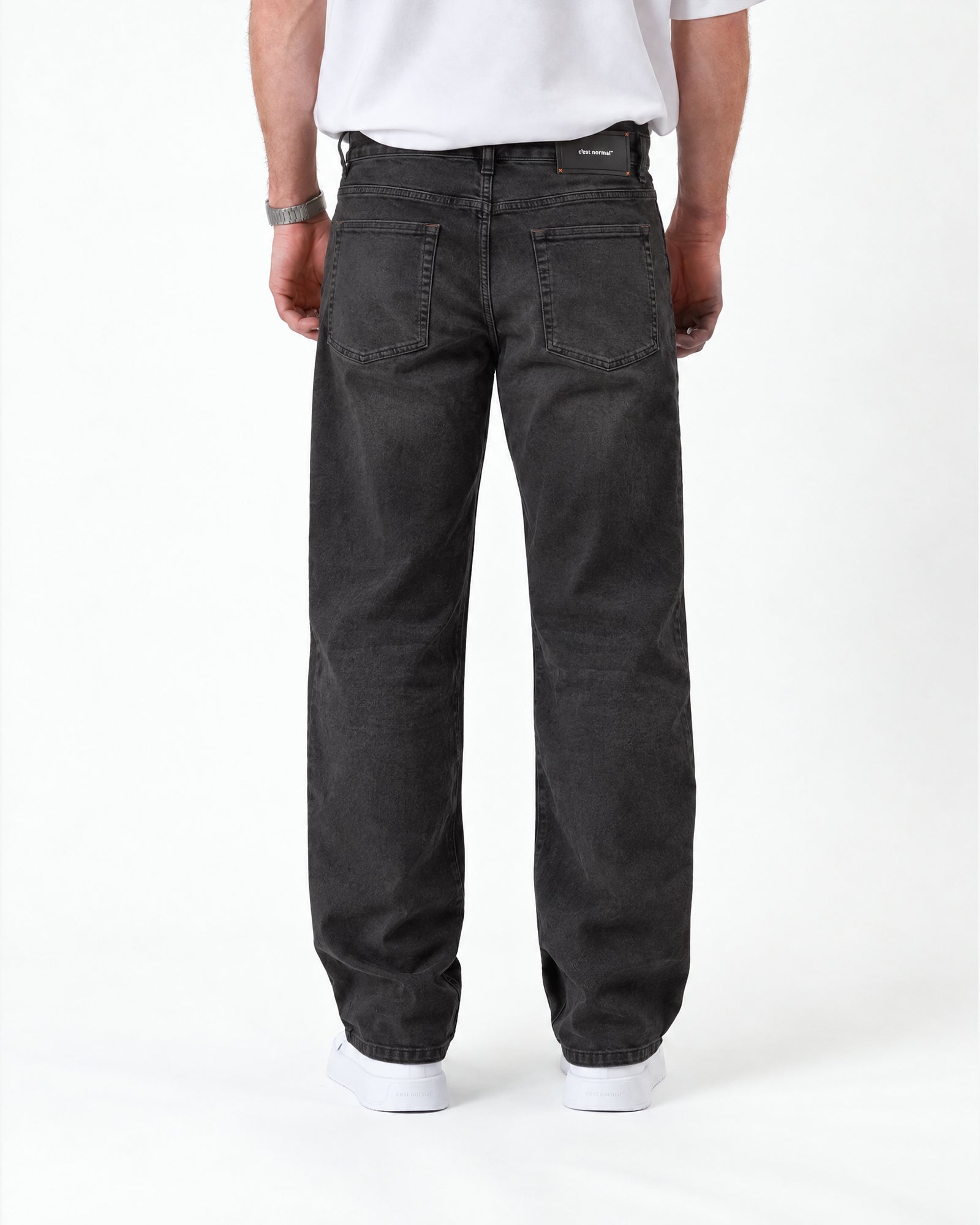 The Jeans Relaxed Straight Fit in faded black — back view with a rubber patch at the waist