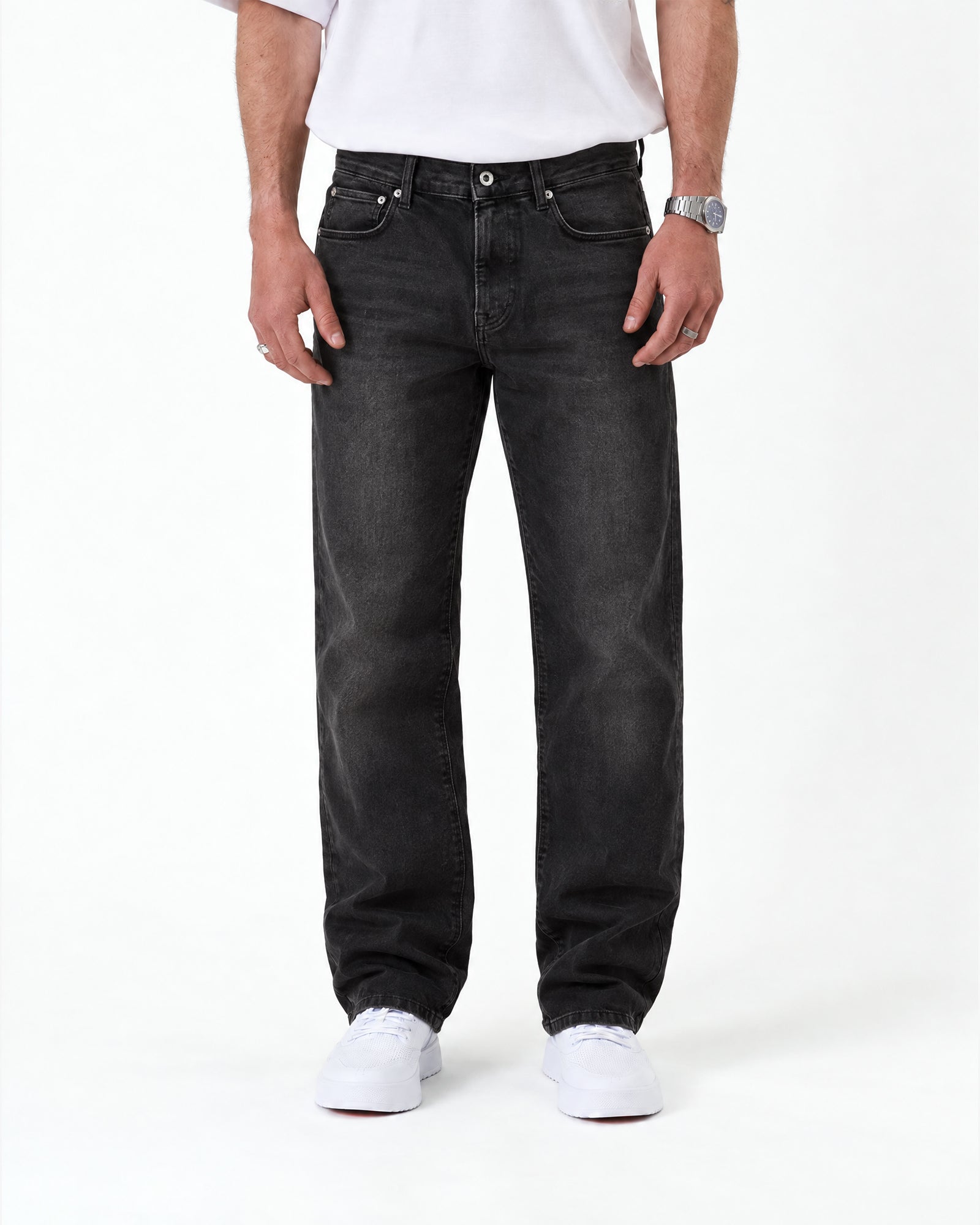 The Jeans Relaxed Straight Fit in faded black — front view worn with white sneakers