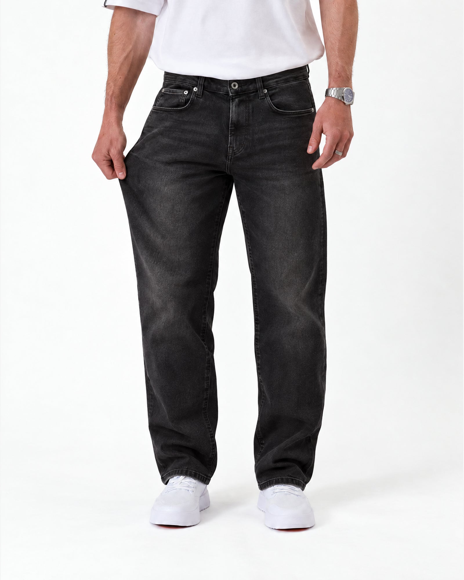 The Jeans Relaxed Straight Fit in faded black — showing fabric stretch