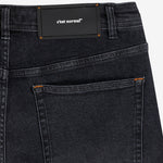 The Jeans Relaxed Straight Fit in faded black — close-up of the back waist patch and pocket