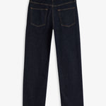 A back view of The Jeans Relaxed Straight Fit in Rinse Wash, laid flat on a white background. The image highlights the straight leg silhouette, two back pockets, subtle orange accent stitching, and the rubber patch at the back waist with the c'est normal logo.