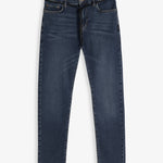 A front view of The Jeans Skinny Fit in midwash, laid flat on a white background. The image highlights the skinny leg cut, classic front pockets, and a black drawstring tie at the waist.