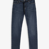 A front view of The Jeans Skinny Fit in midwash, laid flat on a white background. The image highlights the skinny leg cut, classic front pockets, and a black drawstring tie at the waist.