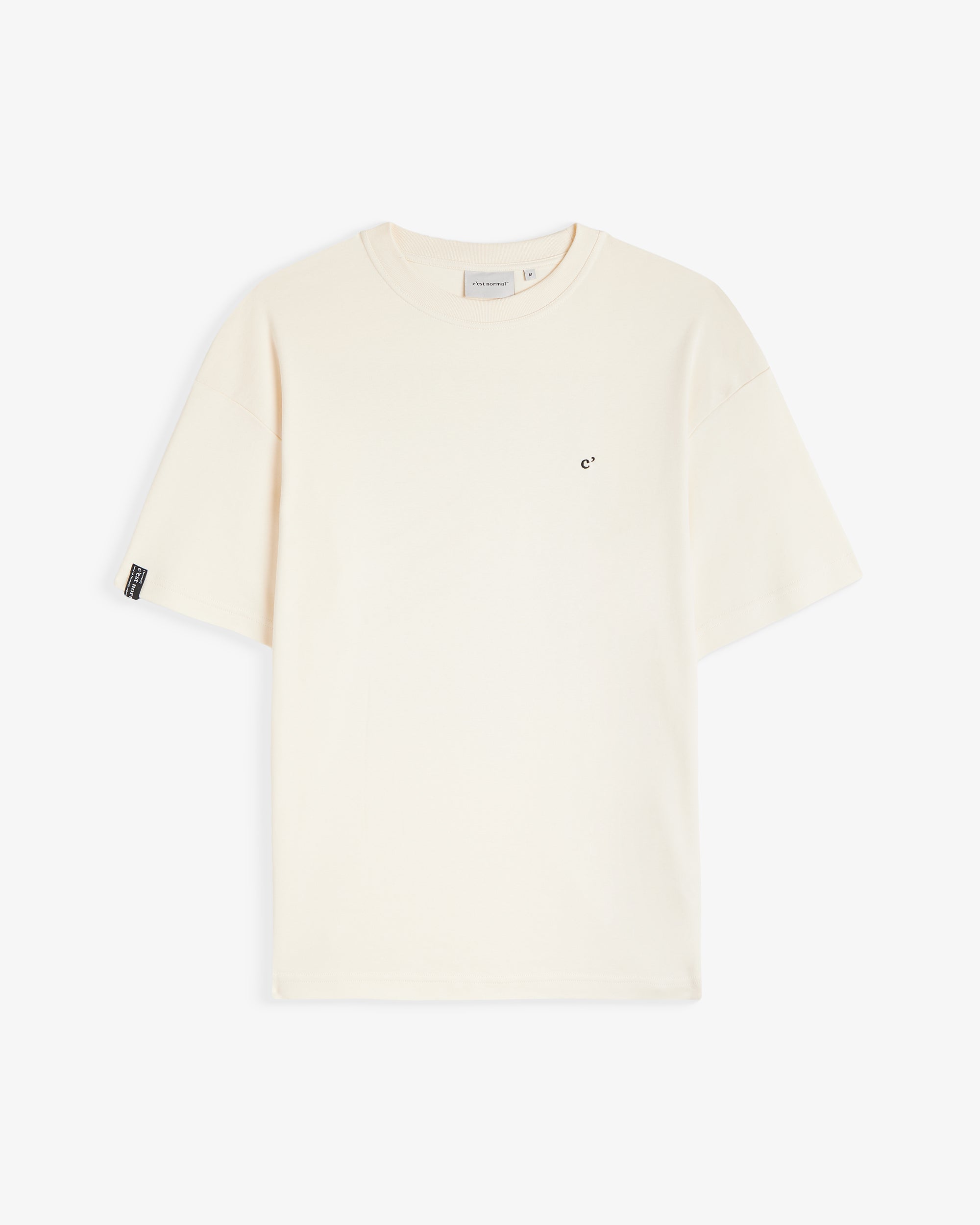 The Oversized Printed T-shirt in cream — laid flat with a small black logo on the chest