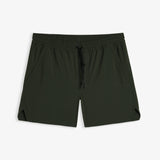 A front view of The Shorts in khaki, laid flat on a white background. The image highlights the elasticated waistband with a black drawstring, side pockets, notched hem, and a subtle c'est normal logo on the left leg.