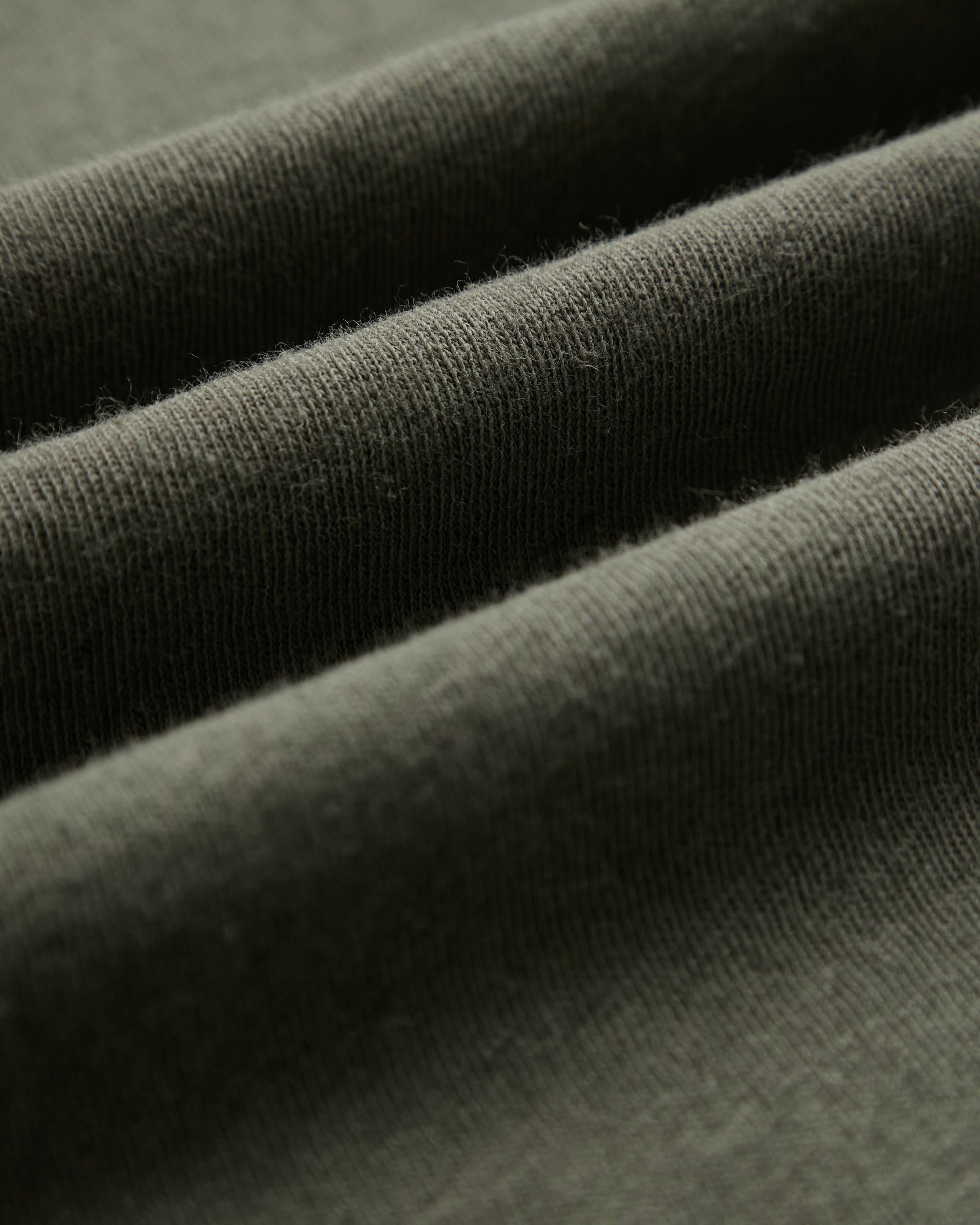 The Sanremo Linen Tee in Mulled Green — close-up of the textured linen-cotton jersey fabric