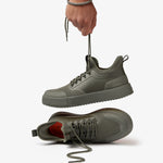 The Sneakers 2.0 in khaki — being held up by the laces