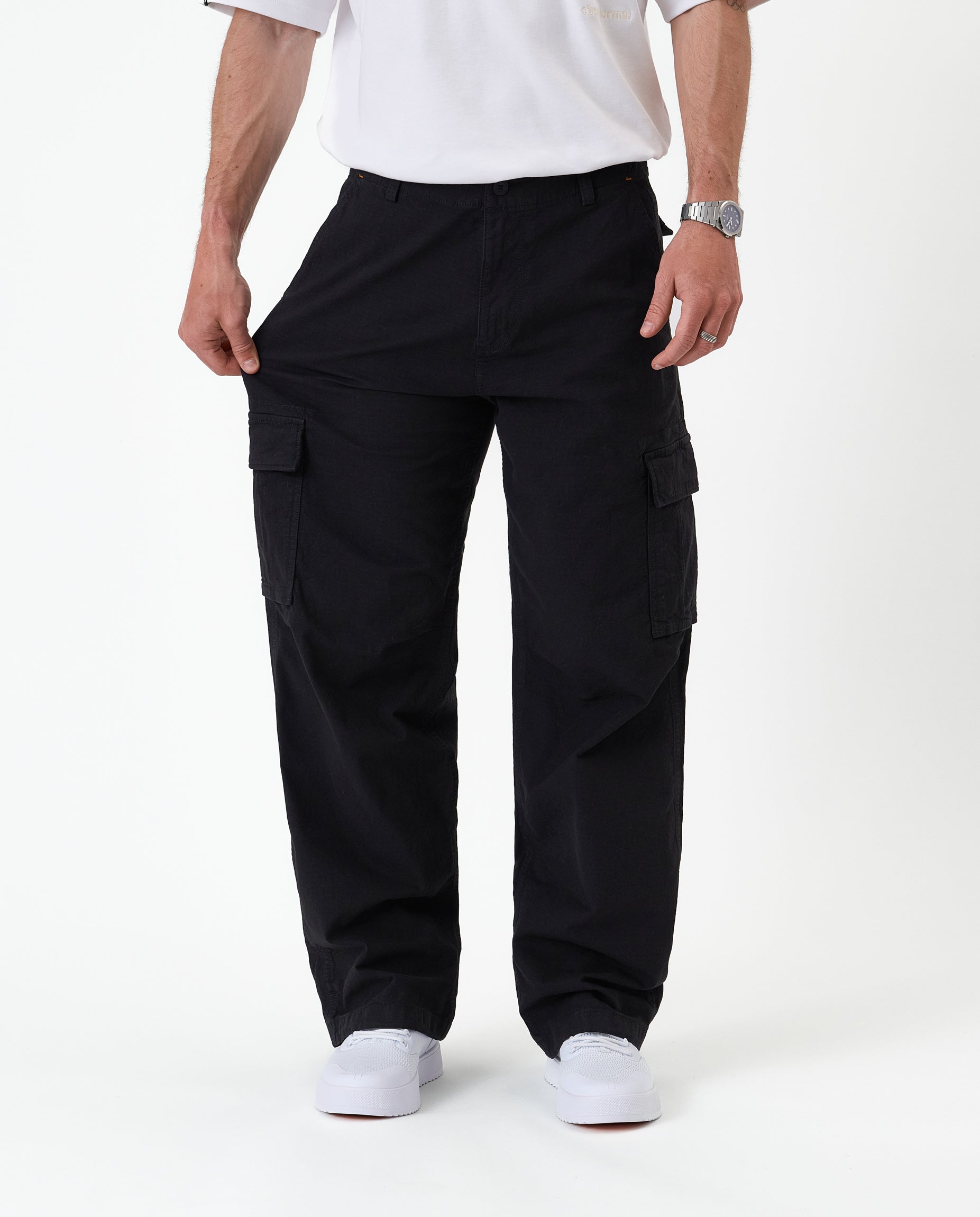 The Monterey Cargo Pant in black — stretching the fabric to show the flexible comfort stretch