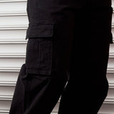 The Monterey Cargo Pant in black — close-up of the angled cargo flap pocket