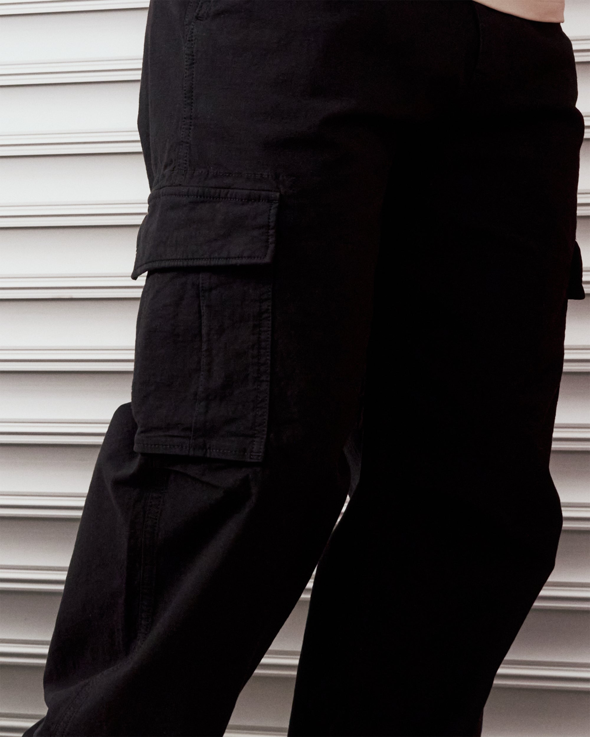 The Monterey Cargo Pant in black — close-up of the angled cargo flap pocket