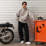 The Monterey Cargo Pant in black — worn with a grey hoodie next to a motorcycle