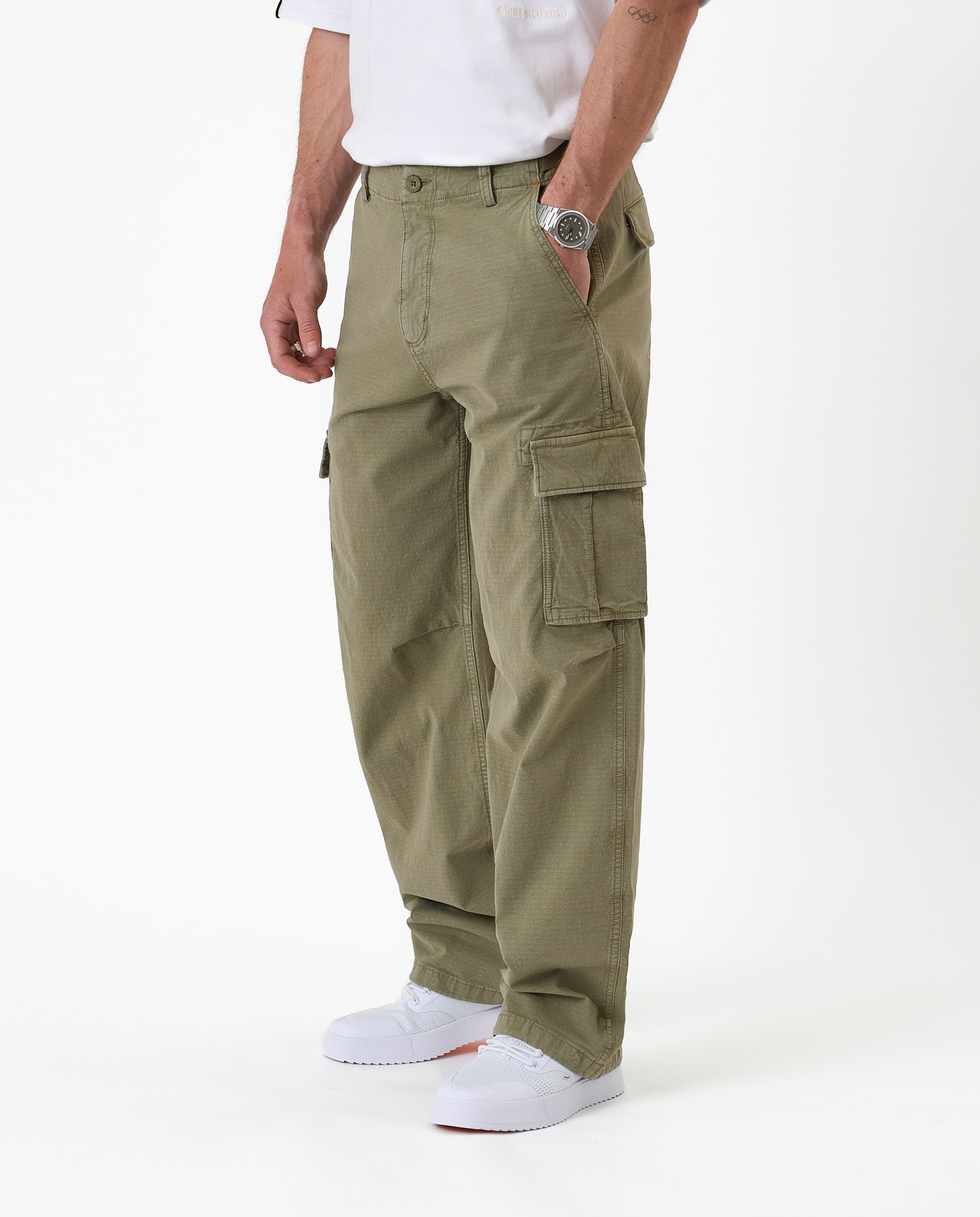 The Monterey Cargo Pant in Light Khaki — side view showing the cargo pocket and white sneakers