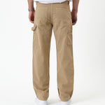 The Carpenter Pant in beige — back view showing utility pockets and hammer loop