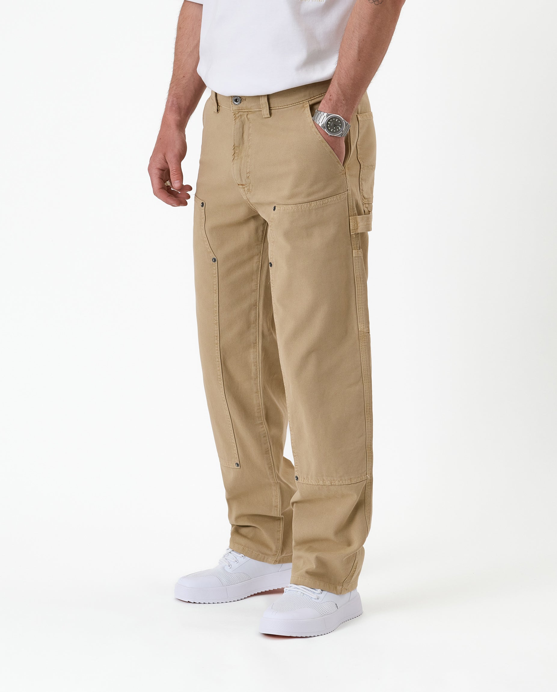 The Carpenter Pant in beige — side view showing the hammer loop and utility pockets