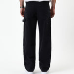 The Carpenter Pant in black — back view with C'est normal patch and hammer loop