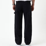 The Carpenter Pant in black — back view with C'est normal patch and hammer loop