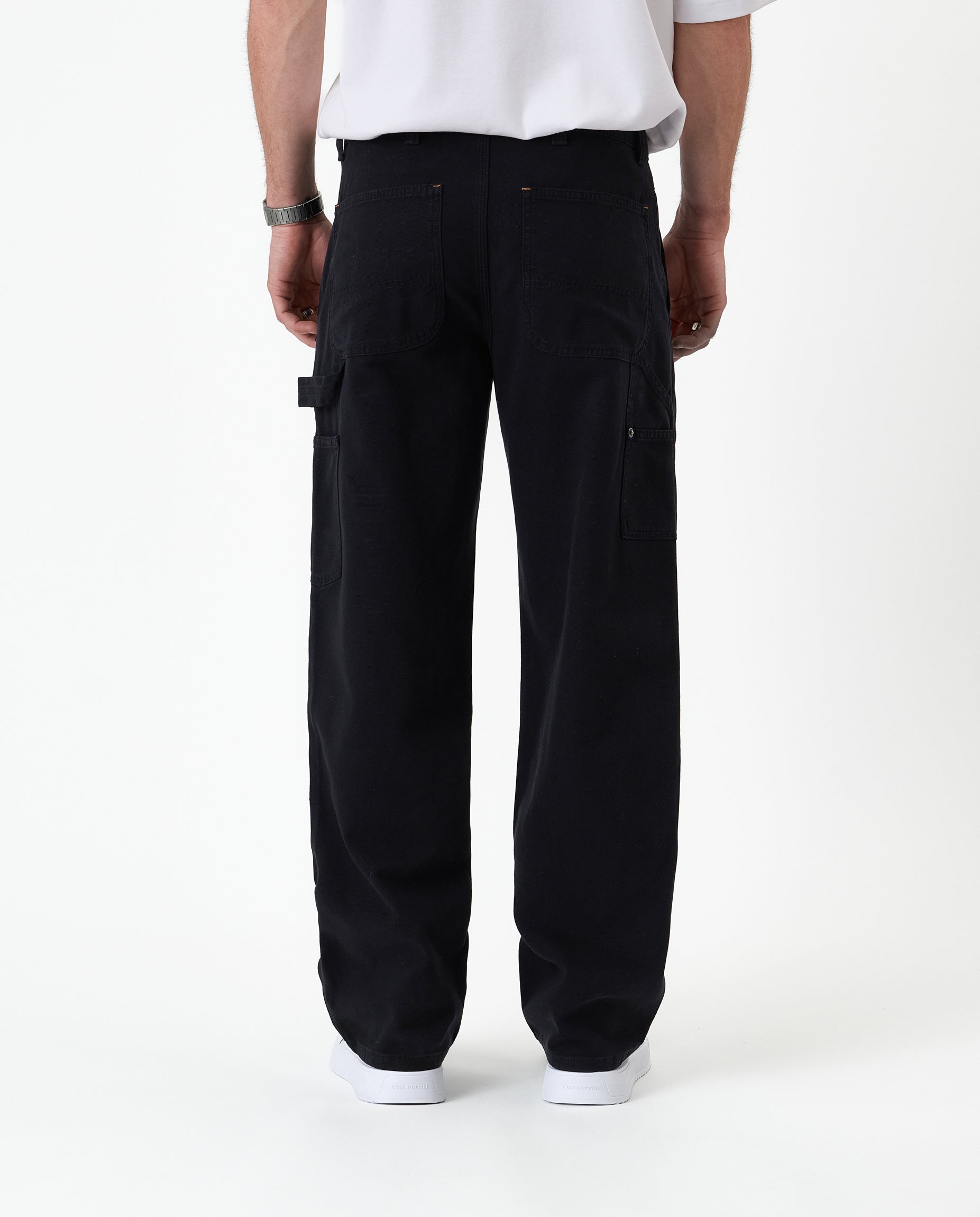 The Carpenter Pant in black — back view with C'est normal patch and hammer loop