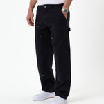 The Carpenter Pant in black — side view showing the hammer loop and copper-toned rivets