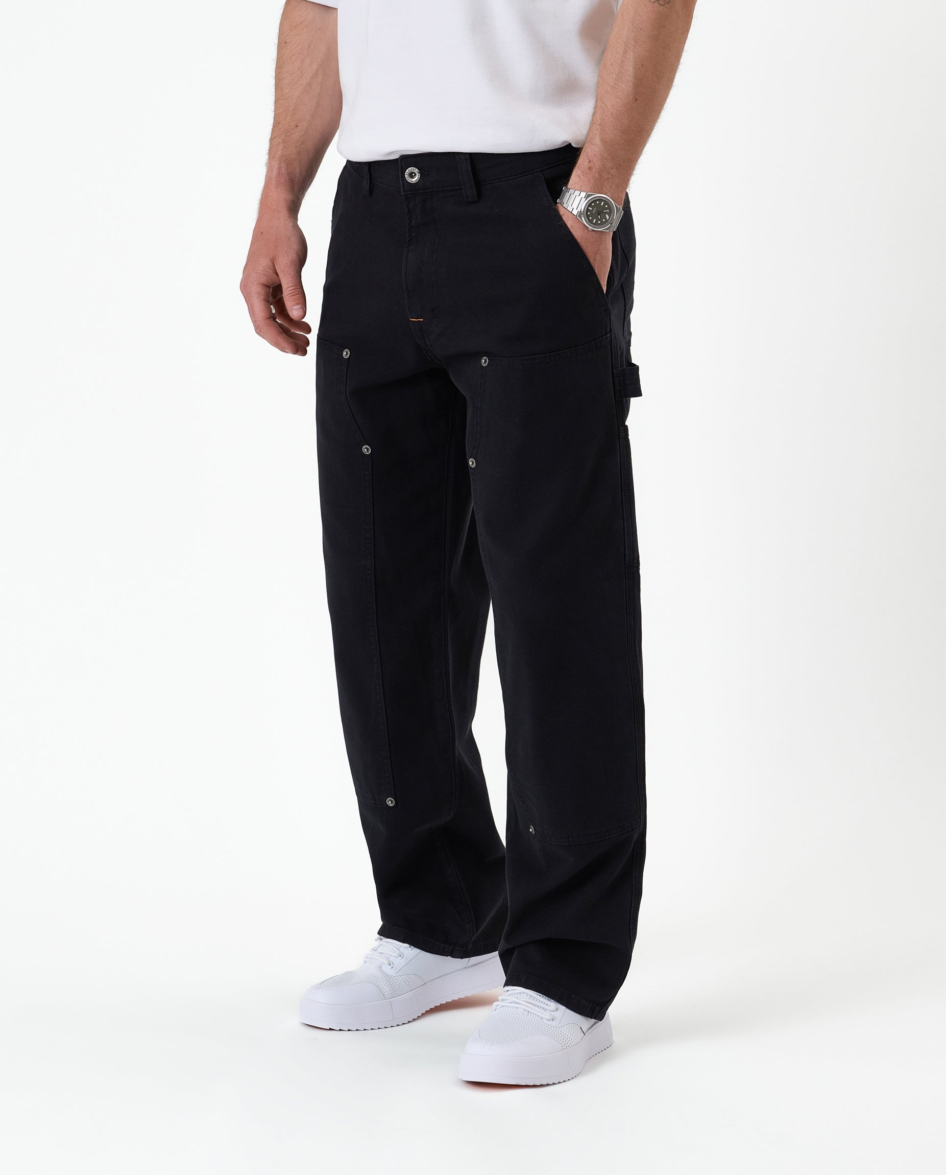 The Carpenter Pant in black — side view showing the hammer loop and copper-toned rivets