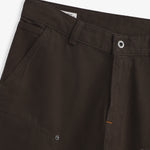 The Carpenter Pants in brown — close-up of the waistband and button closure