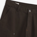 The Carpenter Pants in brown — close-up of the waistband and button closure