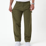 The Carpenter Pant in olive green — pulling the leg fabric to demonstrate the stretch material