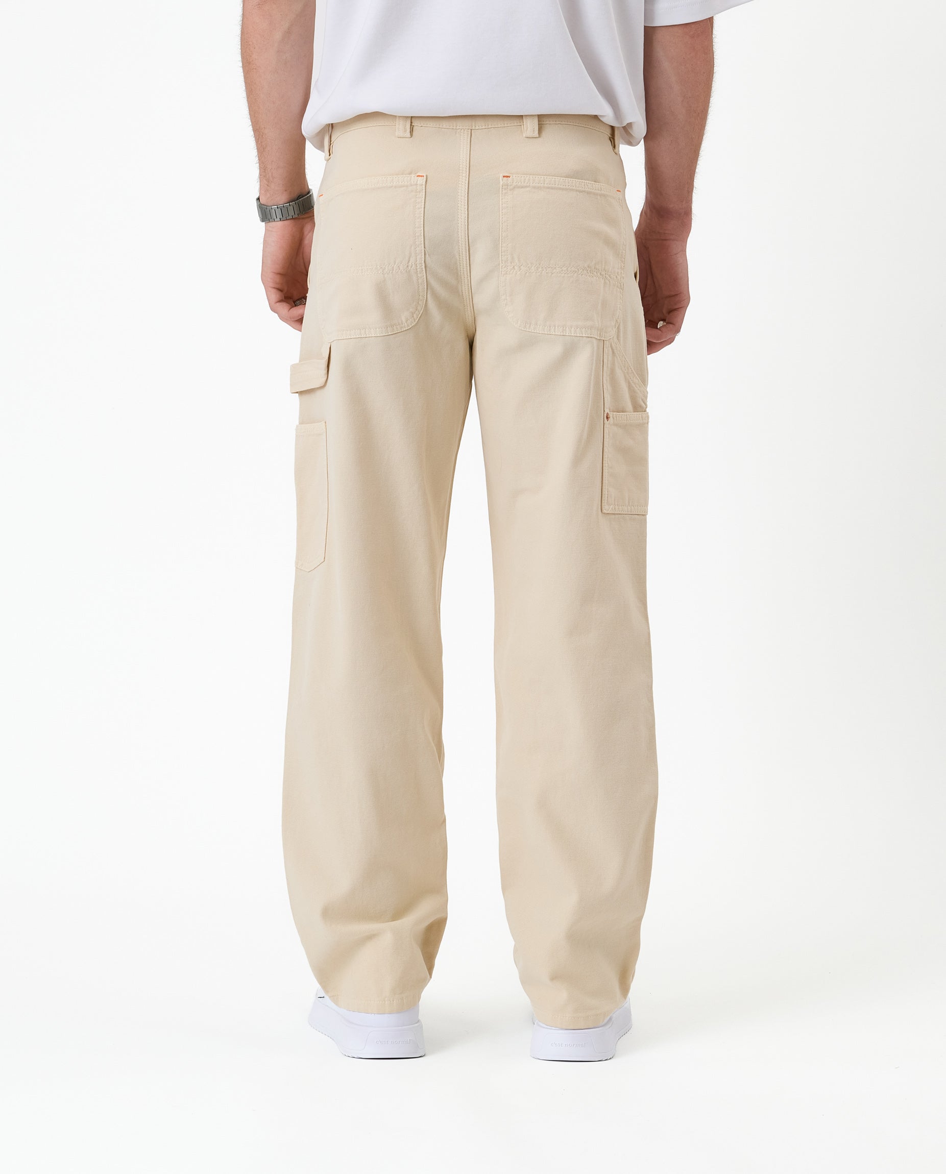 The Carpenter Pant in sand — back view with utility pockets and hammer loop