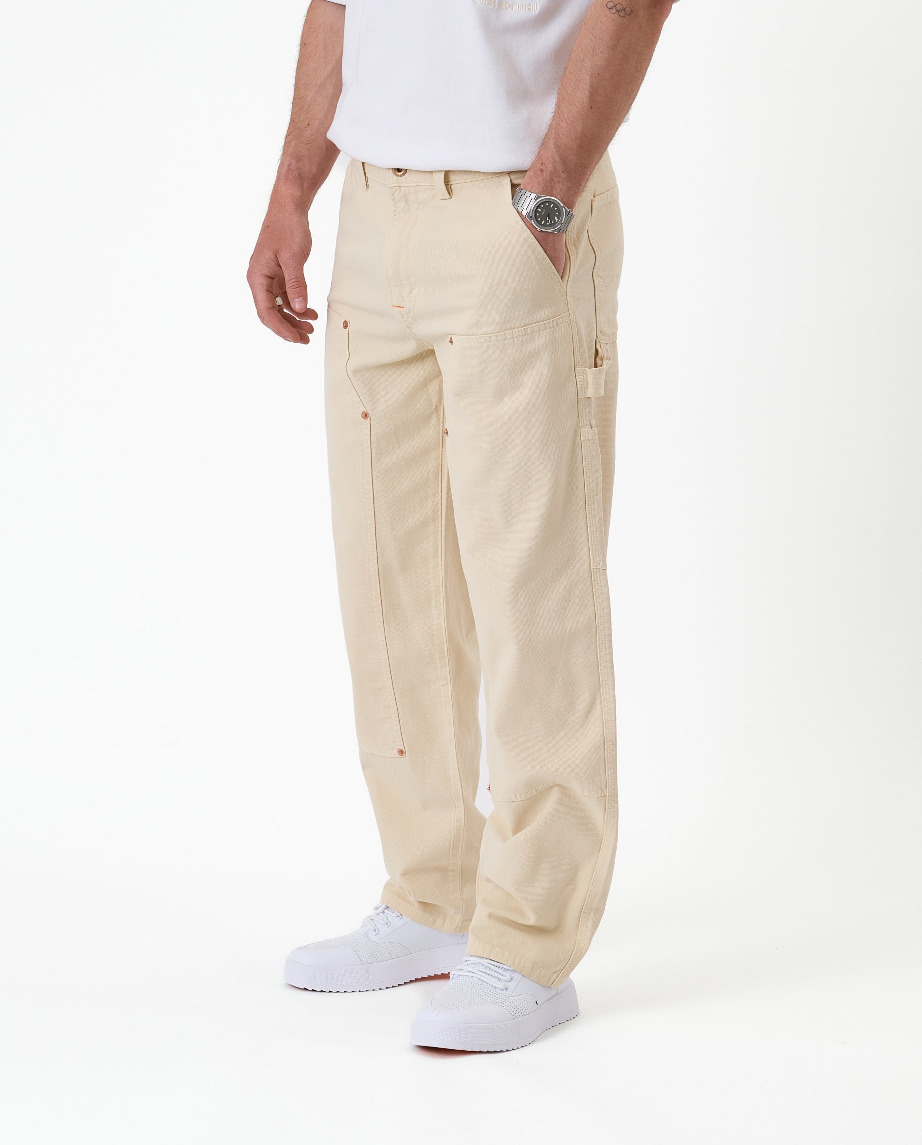 The Carpenter Pant in sand — side view featuring the hammer loop and white sneakers