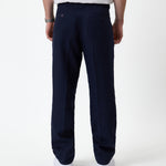 The Daily Linen Trouser in navy — back view showing the welt pockets and pressed crease