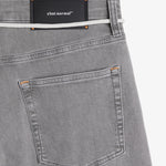 The Jeans Relaxed Straight Fit in light grey — close-up of the back waist with a rubber patch and C'est normal logo