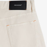 The Jeans Relaxed Straight Fit in ecru — back view with a black C'est normal rubber patch