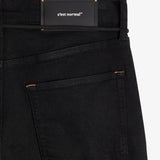 The Jeans Relaxed Straight Fit in jet black — back view with the black C'est normal rubber patch