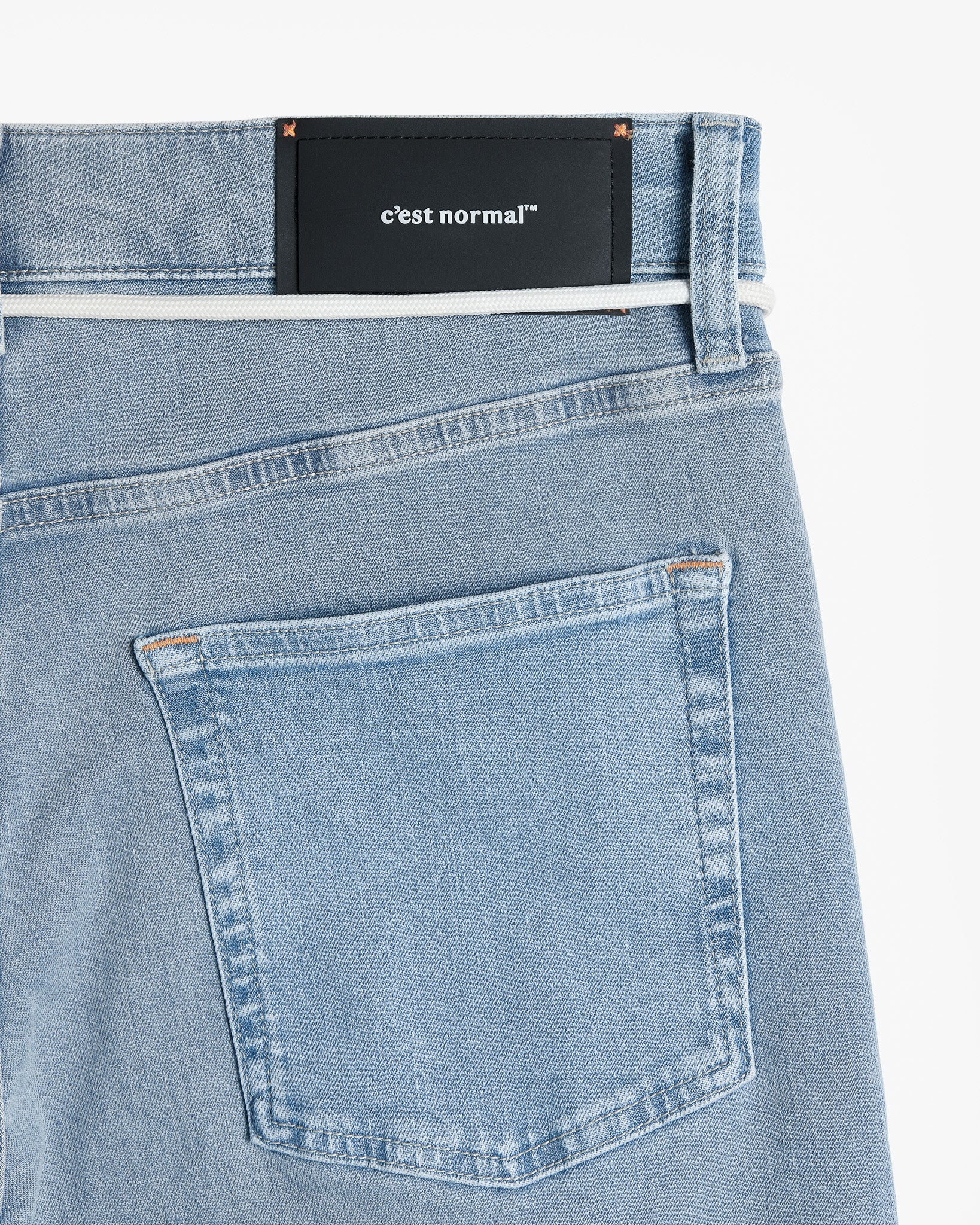 The Jeans Relaxed Straight Fit in light blue — back view with the C'est normal rubber patch