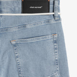 The Jeans Relaxed Straight Fit in light blue — back view with the black C'est normal rubber patch