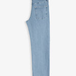 The Jeans Relaxed Straight Fit in light blue — folded view highlighting the back pocket and rubber patch