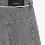 The Jeans Relaxed Straight Fit in light grey — back pocket and black C'est normal rubber patch