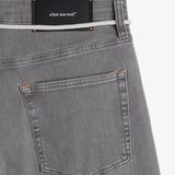 The Jeans Relaxed Straight Fit in light grey — back pocket and black C'est normal rubber patch