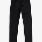 A back view of The Jeans Slim Fit in Jet Black, laid flat on a white background. The image highlights the two back pockets, subtle orange accent stitching, and a rubber patch at the back waist featuring the c'est normal logo.