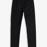 A back view of The Jeans Slim Fit in Jet Black, laid flat on a white background. The image highlights the two back pockets, subtle orange accent stitching, and a rubber patch at the back waist featuring the c'est normal logo.