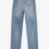 A back view of The Jeans Slim Fit in Light Midwash, laid flat on a white background. The image highlights the two back pockets and the black rubber patch at the back waist with the c'est normal logo.