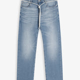 A front view of The Jeans Slim Fit in Light Midwash, laid flat on a white background. The image highlights the clean slim leg silhouette, subtle fade patterns, front pockets, zip fly with top button, and a white drawstring tied around the waist.
