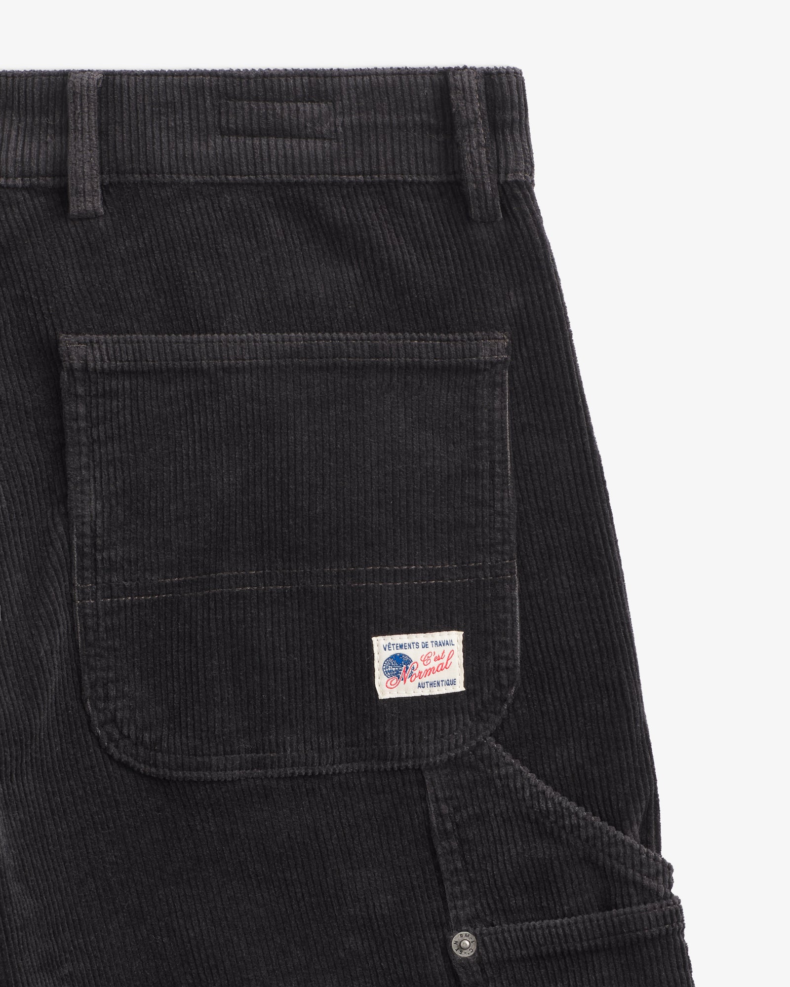 The Lille Cord Carpenter Pant in anthracite — close-up of the back pocket and logo label
