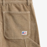The Lille Cord Carpenter Pant in dark sand — close-up of the back pocket and logo label