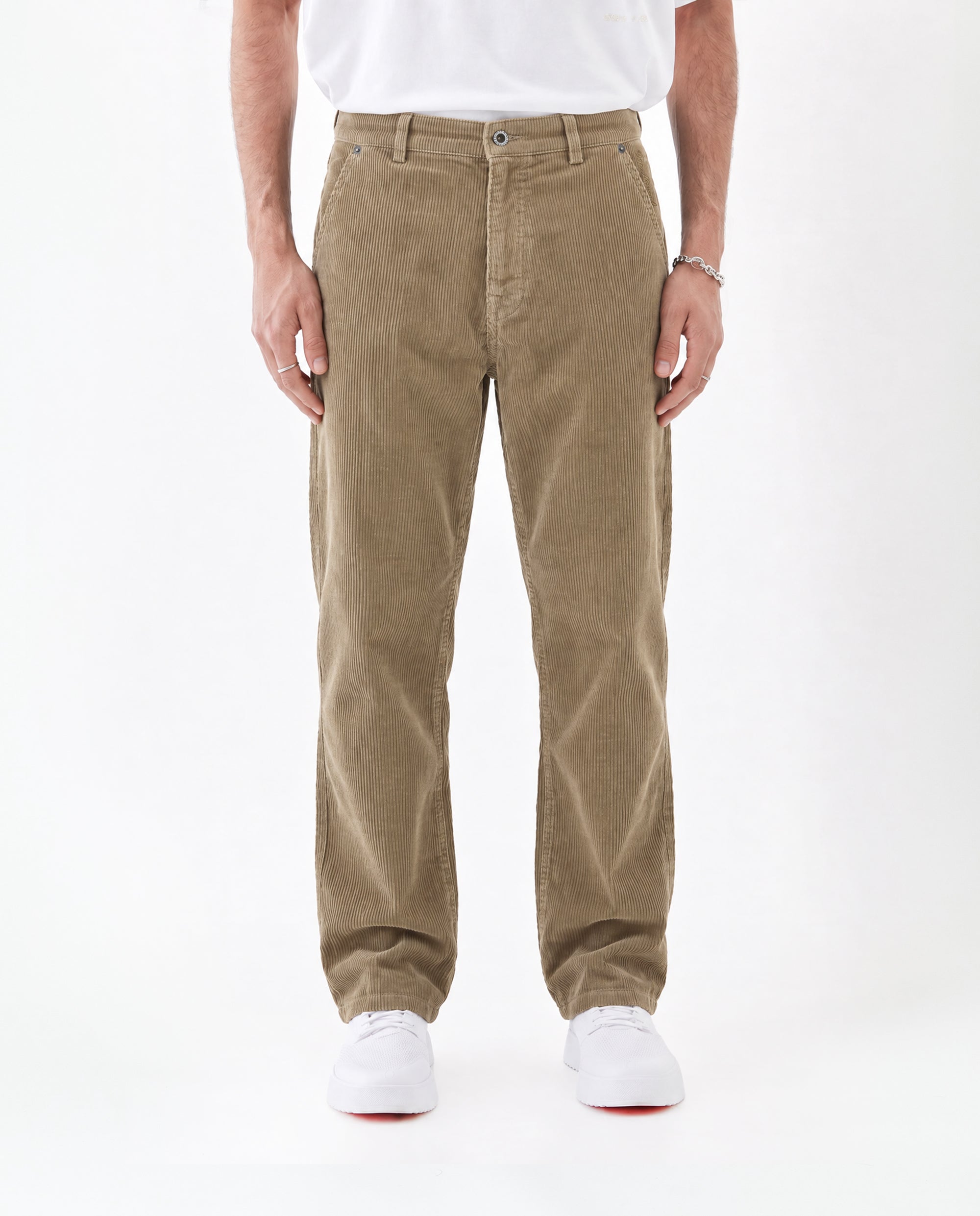 The Lille Cord Carpenter Pant in dark sand — front view worn with white sneakers