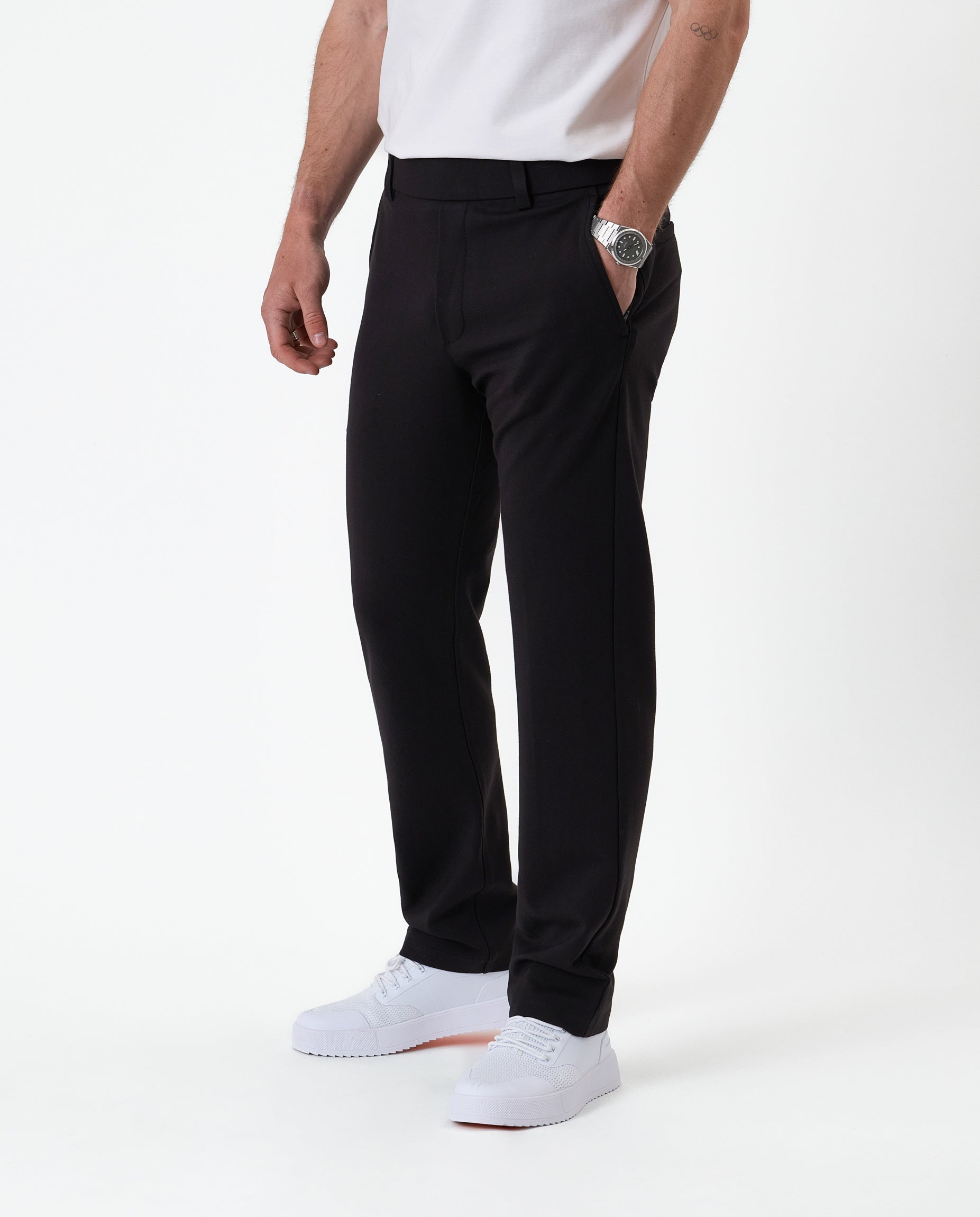 The Proper Pant Regular Fit in black — side view worn with white sneakers